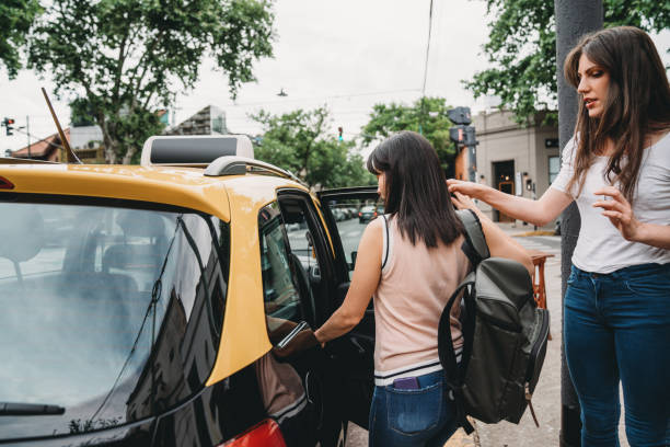 Two young adult women getting in the cab in Buenos Aires.